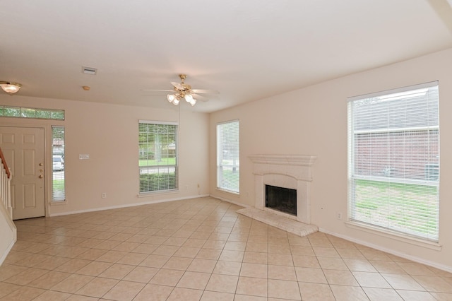 unfurnished living room featuring light tile patterned floors, a premium fireplace, and ceiling fan