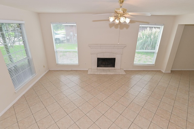 unfurnished living room with ceiling fan, a premium fireplace, and a wealth of natural light