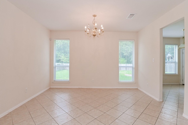 unfurnished room with a chandelier and light tile patterned floors