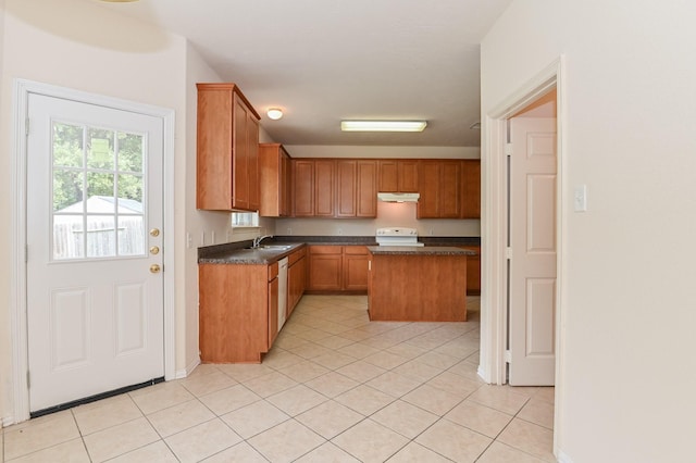 kitchen featuring light tile patterned floors, sink, a kitchen island, and stove