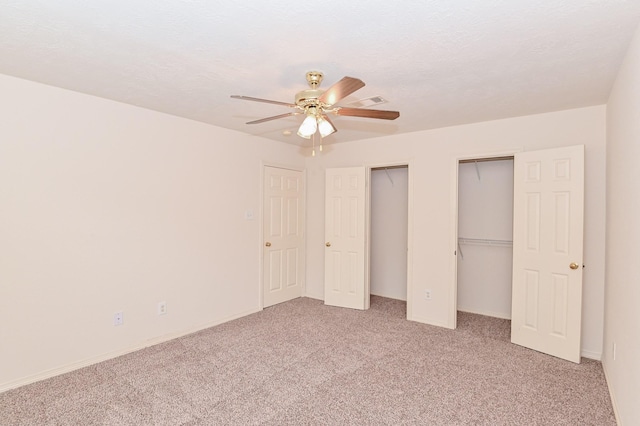 unfurnished bedroom with ceiling fan, carpet flooring, and a textured ceiling