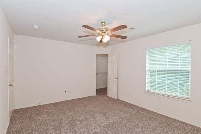 carpeted empty room featuring ceiling fan