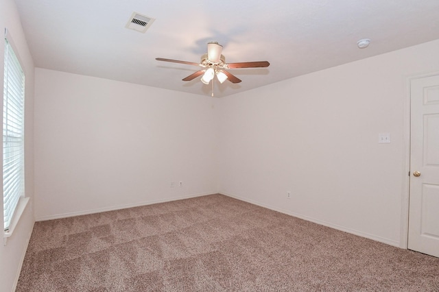 carpeted spare room featuring ceiling fan