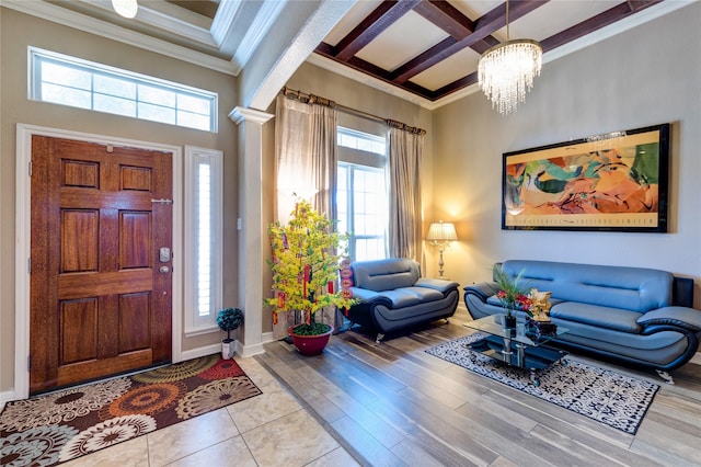 foyer featuring decorative columns, beamed ceiling, ornamental molding, coffered ceiling, and light hardwood / wood-style flooring