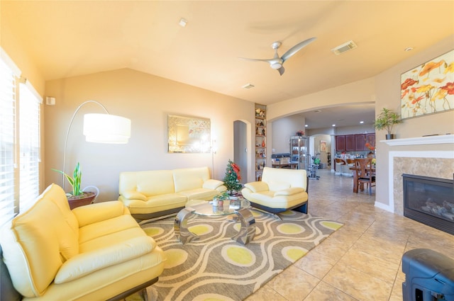 living room with lofted ceiling, light tile patterned floors, and ceiling fan