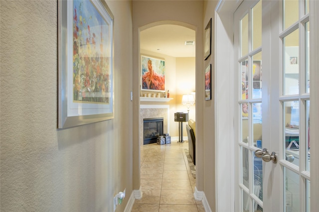 corridor featuring french doors and light tile patterned flooring