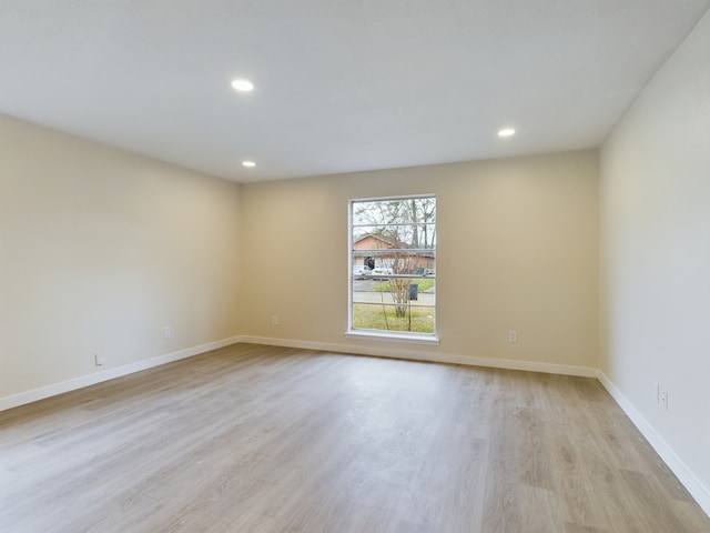 empty room featuring recessed lighting, baseboards, and light wood-style floors