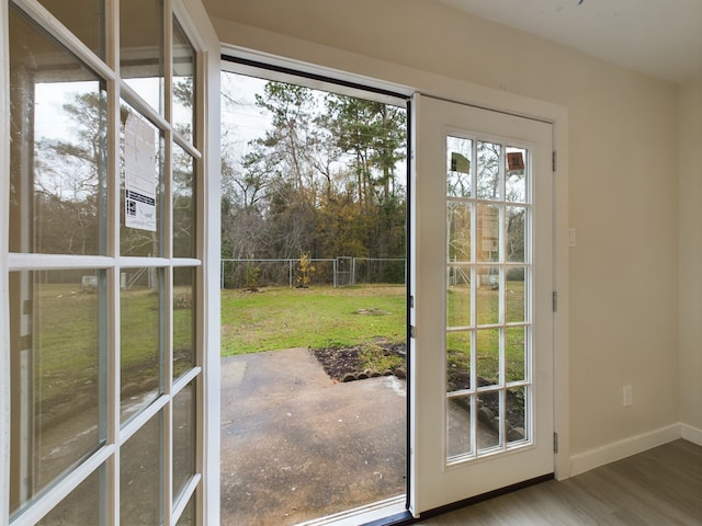 doorway featuring wood finished floors and baseboards