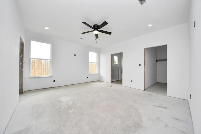 unfurnished bedroom with a walk in closet and ceiling fan