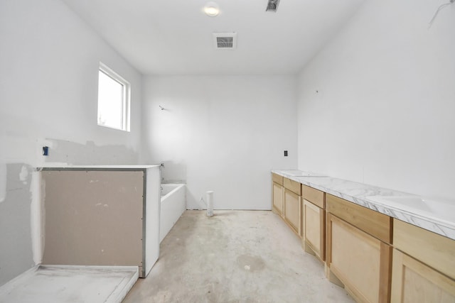 bathroom featuring a bath and concrete floors