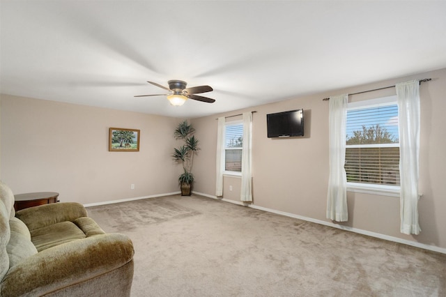 living area with ceiling fan, light carpet, and a healthy amount of sunlight