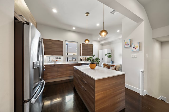 kitchen featuring sink, stainless steel fridge, hanging light fixtures, dark hardwood / wood-style floors, and a center island