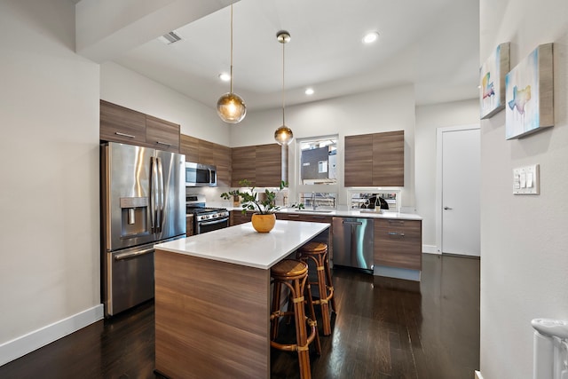 kitchen featuring sink, dark hardwood / wood-style floors, a center island, and appliances with stainless steel finishes