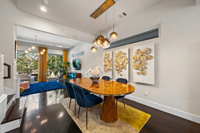 dining space with hardwood / wood-style flooring and a notable chandelier