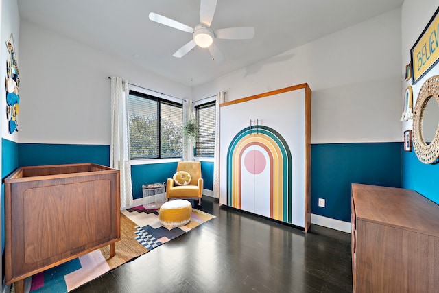 sitting room featuring dark wood-type flooring and ceiling fan