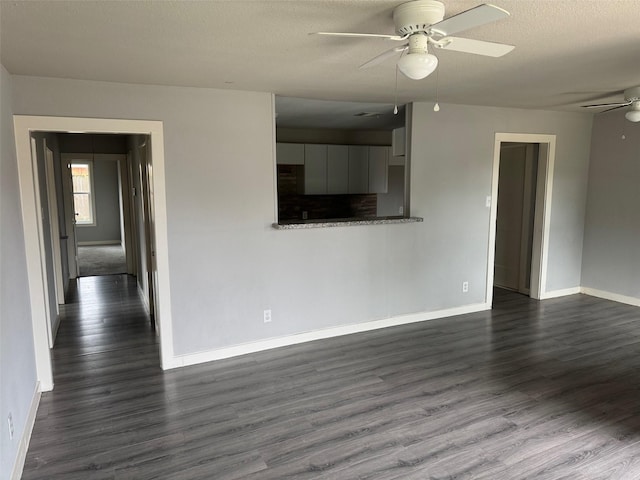 unfurnished living room featuring dark hardwood / wood-style flooring, a textured ceiling, and ceiling fan