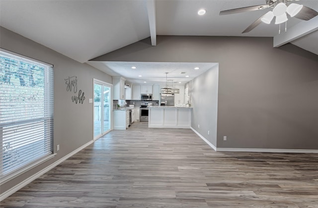 unfurnished living room featuring ceiling fan, light hardwood / wood-style floors, and lofted ceiling with beams