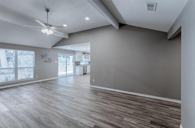 empty room featuring lofted ceiling with beams, hardwood / wood-style flooring, a textured ceiling, and ceiling fan