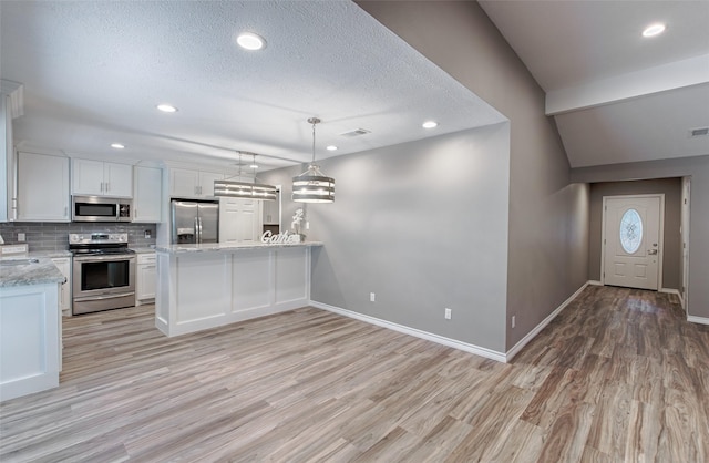 kitchen featuring hanging light fixtures, light hardwood / wood-style flooring, white cabinets, and appliances with stainless steel finishes