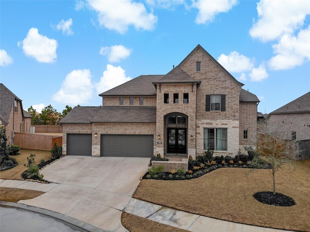 view of front of house featuring an attached garage, driveway, fence, and brick siding