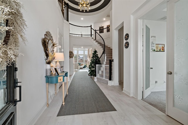 entryway with a high ceiling, stairs, visible vents, and a notable chandelier