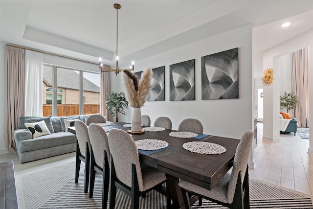 dining room featuring a raised ceiling and a notable chandelier