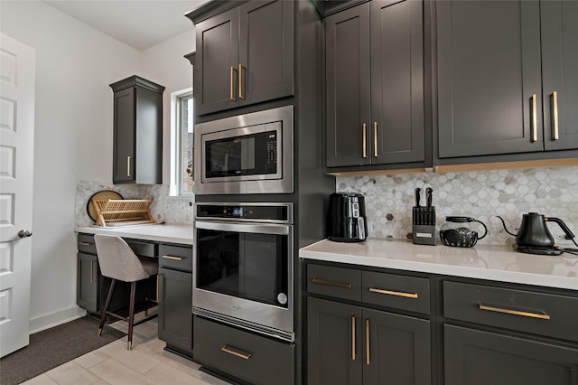 kitchen with tasteful backsplash, appliances with stainless steel finishes, and gray cabinets