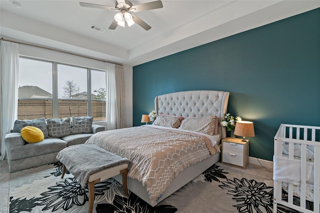 carpeted bedroom with a ceiling fan, visible vents, and baseboards