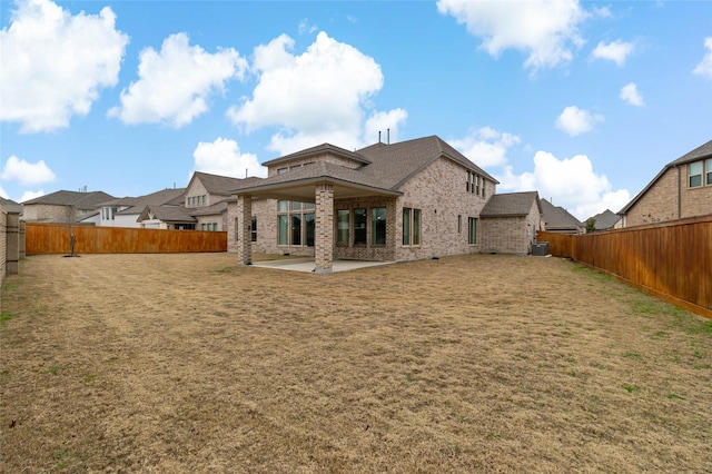 back of house with cooling unit, a patio, and a lawn