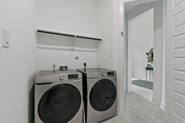 washroom featuring light hardwood / wood-style floors and washing machine and dryer