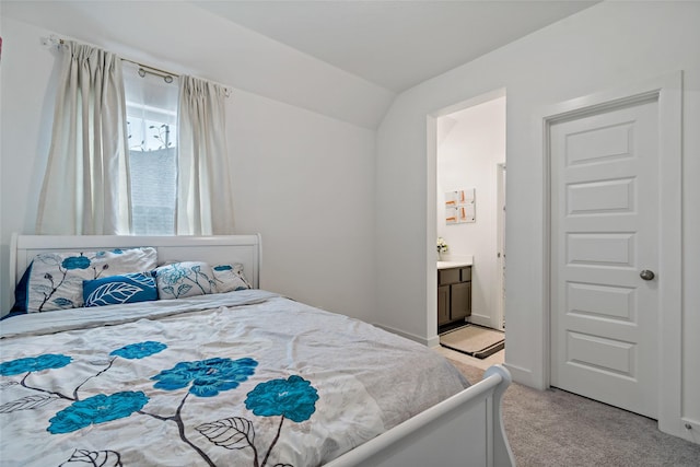 bedroom featuring light carpet, baseboards, connected bathroom, and lofted ceiling