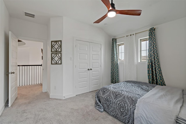 bedroom featuring carpet, visible vents, vaulted ceiling, and a closet