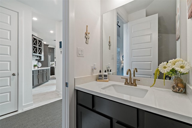 bathroom featuring baseboards, vanity, and recessed lighting