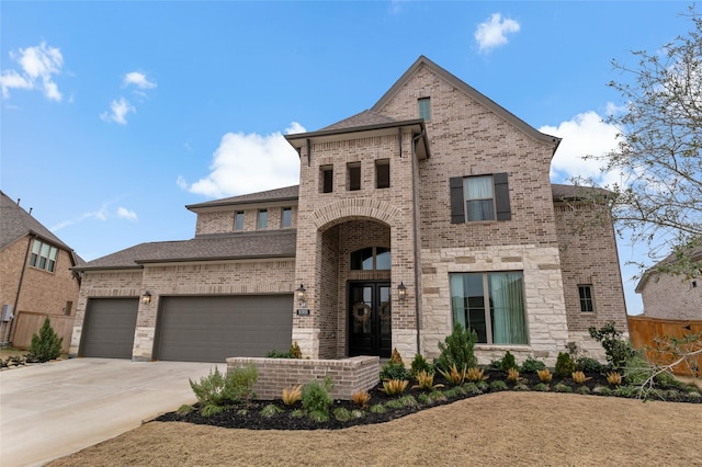 french country home featuring a garage, french doors, and brick siding