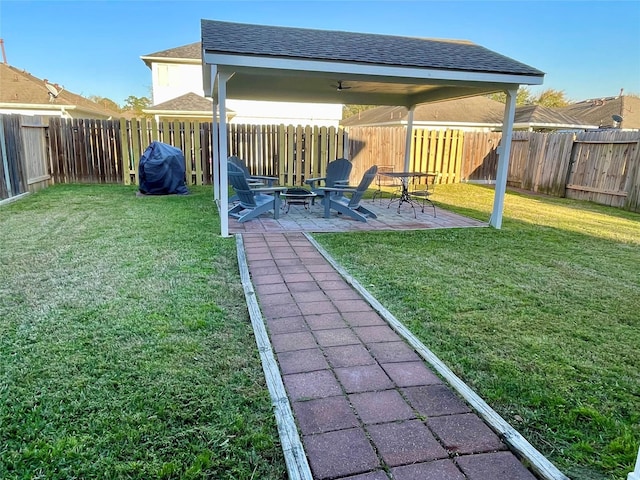 view of yard featuring a fire pit, a fenced backyard, and a patio area