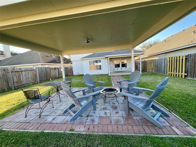 view of patio with ceiling fan, a fire pit, and a fenced backyard