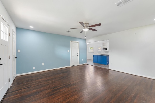 unfurnished living room featuring dark hardwood / wood-style floors and ceiling fan