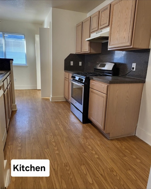 kitchen with tasteful backsplash, gas stove, light brown cabinets, and light hardwood / wood-style flooring