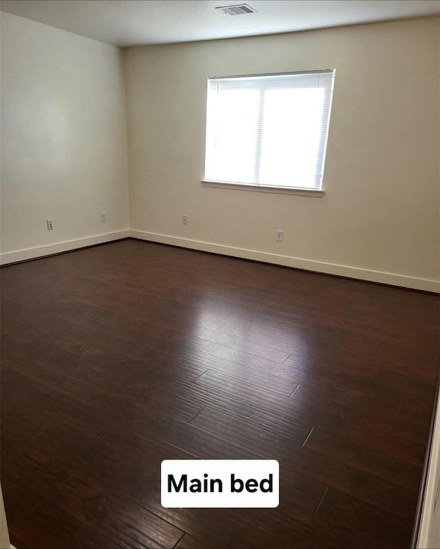 spare room with dark wood-type flooring