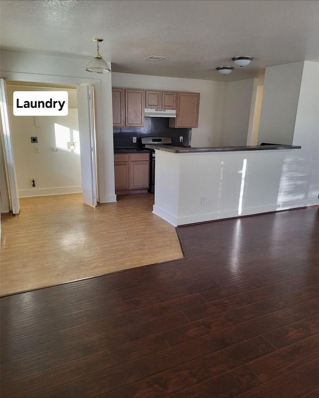 kitchen featuring wood-type flooring, decorative light fixtures, and stainless steel stove