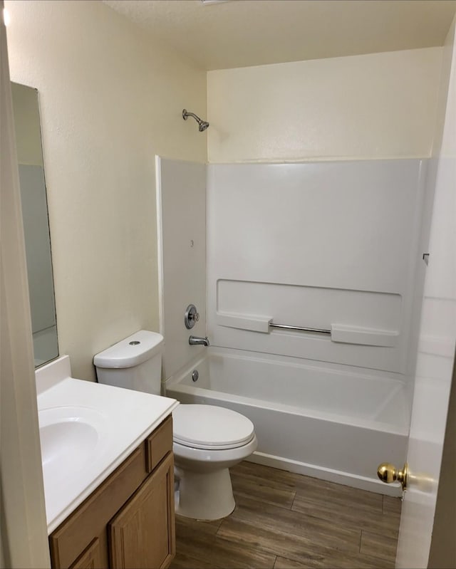 full bathroom featuring vanity, hardwood / wood-style flooring, tub / shower combination, and toilet