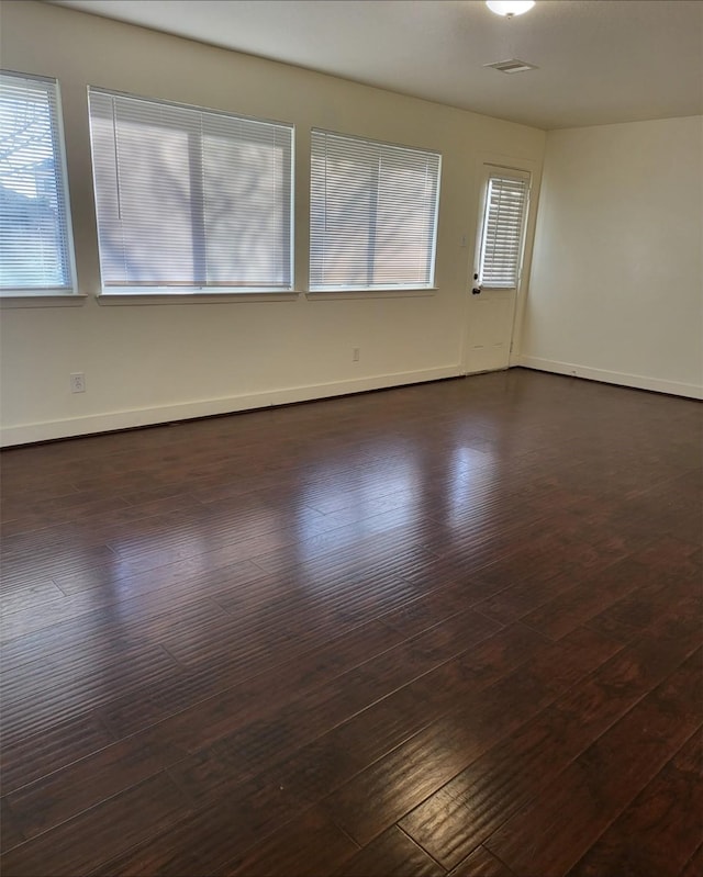 unfurnished room with dark wood-type flooring