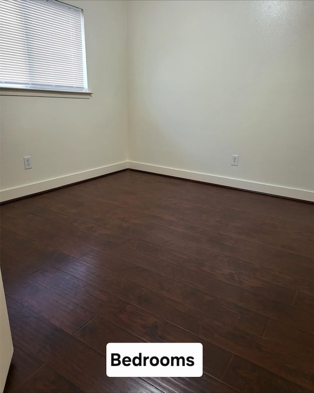 unfurnished room with dark hardwood / wood-style flooring