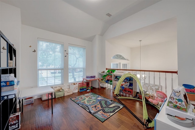 rec room with vaulted ceiling, dark hardwood / wood-style floors, and a notable chandelier