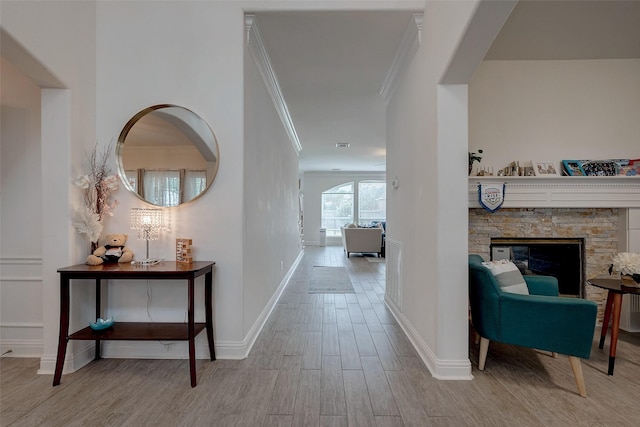 hall with crown molding and light hardwood / wood-style flooring