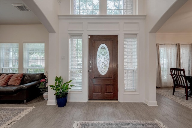 foyer entrance with a towering ceiling and light hardwood / wood-style flooring