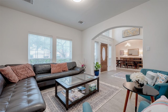 living room with an inviting chandelier and light hardwood / wood-style floors