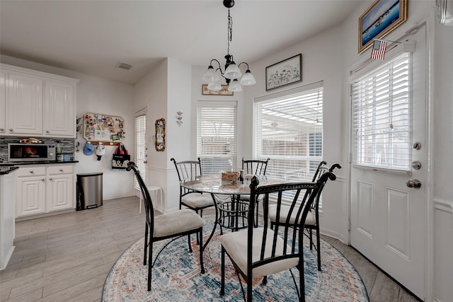 dining room with an inviting chandelier, light hardwood / wood-style floors, and a wealth of natural light