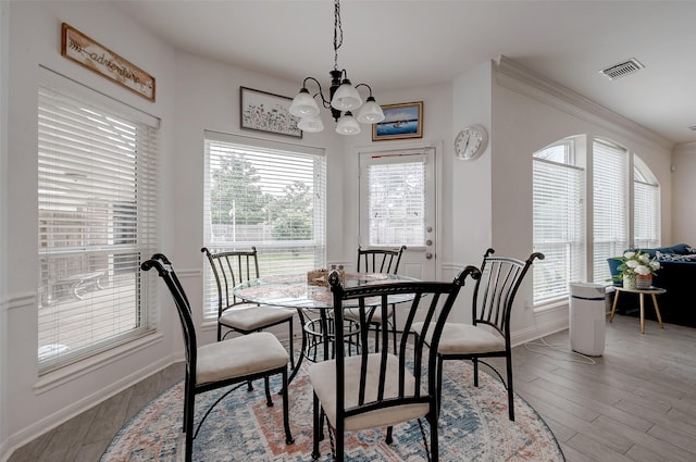 dining space featuring light hardwood / wood-style flooring, a chandelier, and plenty of natural light