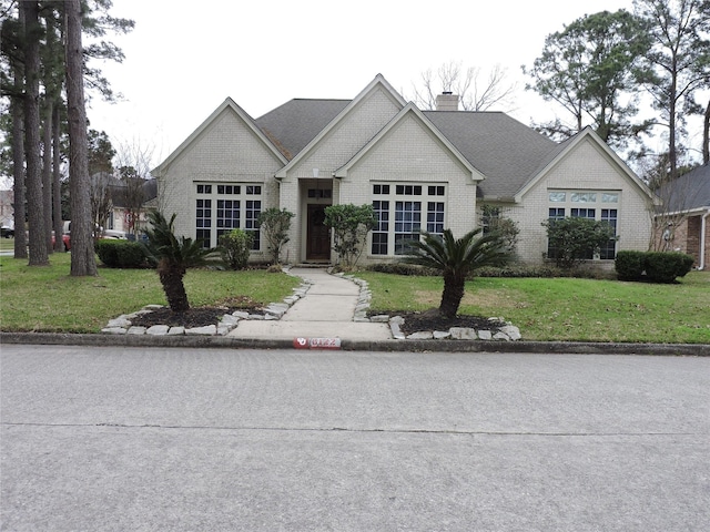 french country inspired facade with a front yard